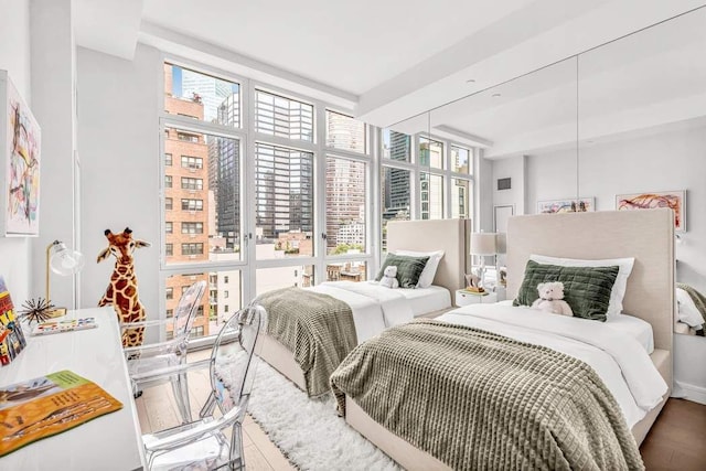 bedroom with hardwood / wood-style flooring, a wall of windows, and multiple windows