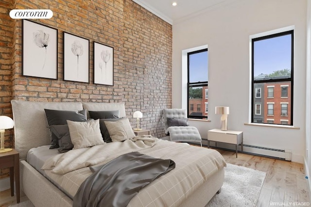 bedroom with baseboard heating, brick wall, light hardwood / wood-style flooring, and crown molding