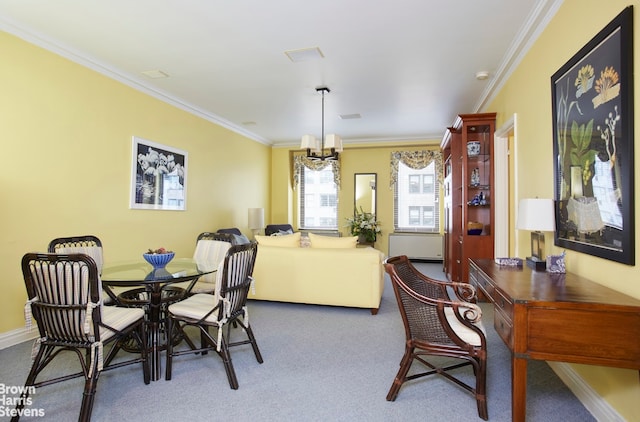 dining room with carpet, a notable chandelier, and ornamental molding