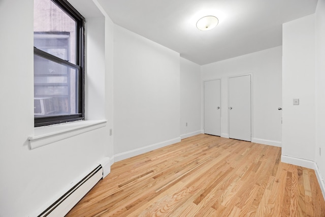 2090 Madison Ave Unit 1D, New York City, NY 10037 - unfurnished bedroom with baseboard heating, wood finished floors, and baseboards