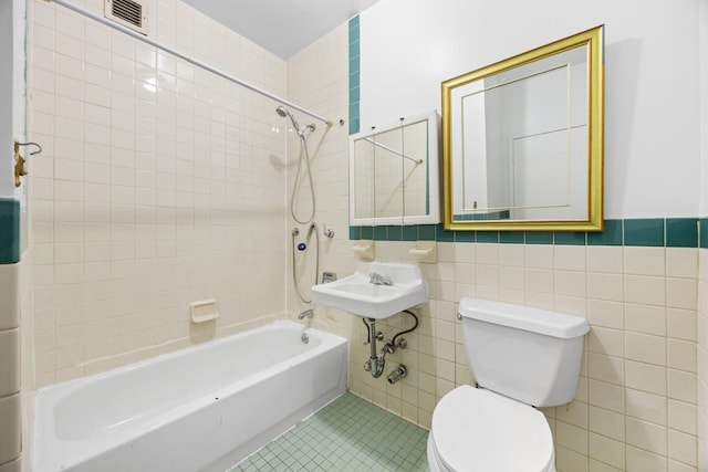 2090 Madison Ave Unit 1D, New York City, NY 10037 - bathroom featuring tile walls, tub / shower combination, toilet, tile patterned flooring, and a sink