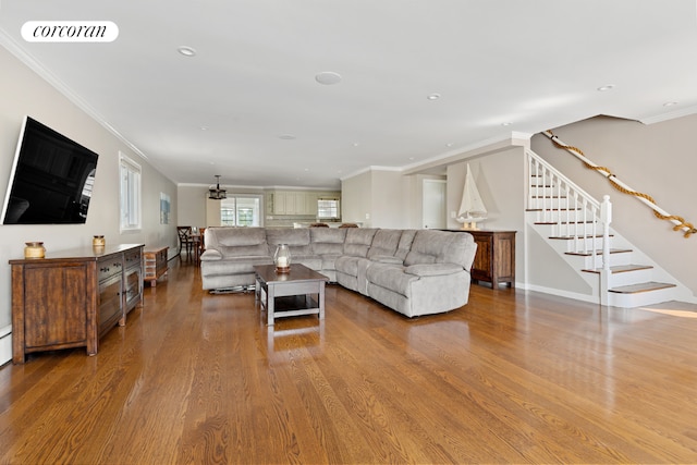 living room with hardwood / wood-style flooring, ornamental molding, and a notable chandelier