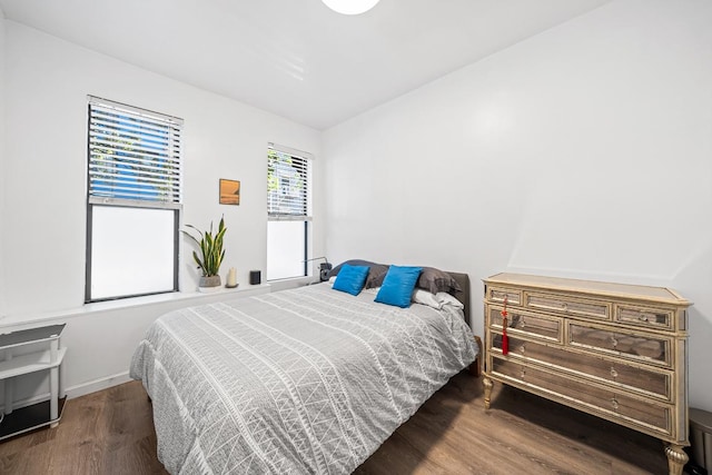 bedroom with dark hardwood / wood-style floors