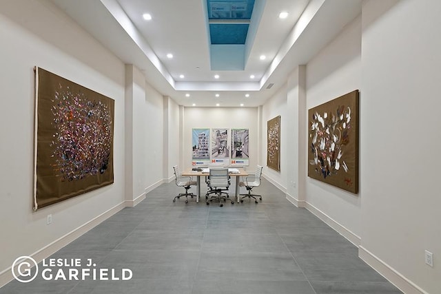 unfurnished dining area featuring concrete floors and a raised ceiling