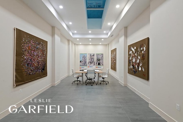 unfurnished dining area featuring a raised ceiling