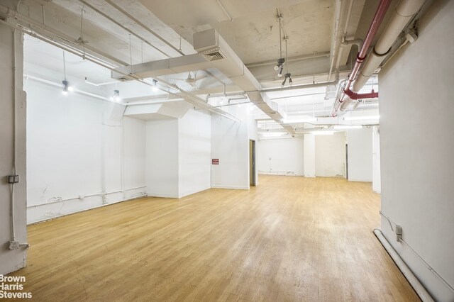 basement with a baseboard heating unit and hardwood / wood-style floors