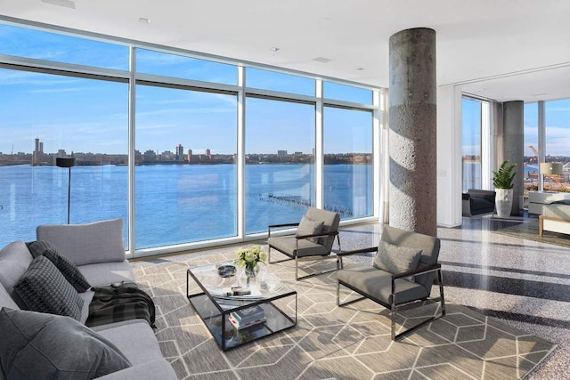 interior space featuring a water view, an outdoor living space, and a city view