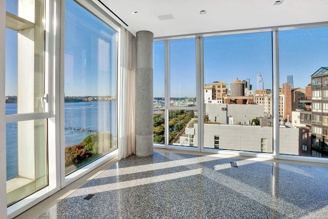 doorway with a city view, plenty of natural light, a water view, and floor to ceiling windows