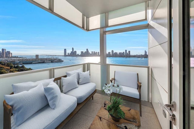 balcony featuring a water view, a view of city, and an outdoor living space