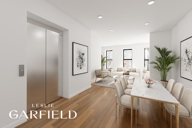 dining area featuring elevator and light wood-type flooring