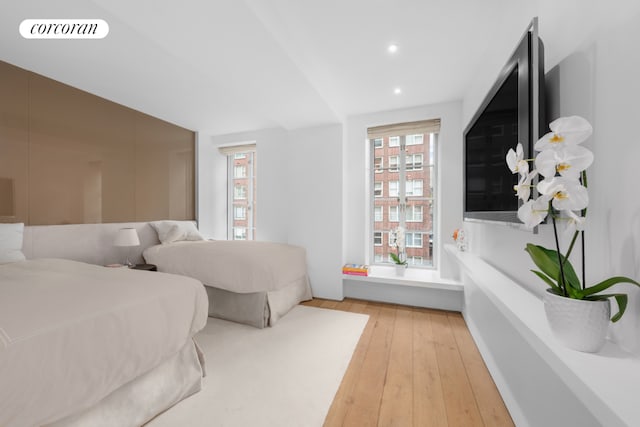 bedroom with light hardwood / wood-style floors and multiple windows