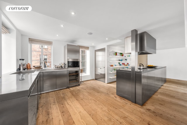 kitchen featuring sink, beverage cooler, and light wood-type flooring