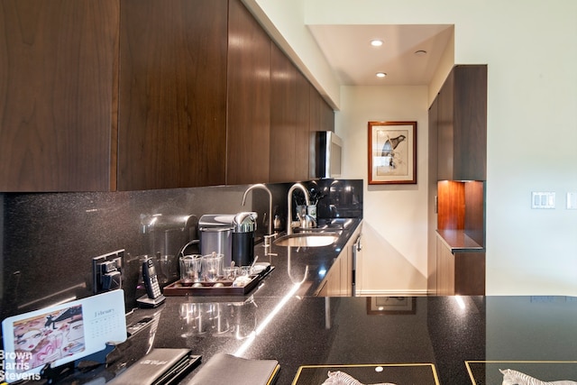 kitchen with dark brown cabinets, modern cabinets, tasteful backsplash, and a sink