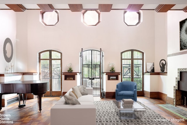 interior space with a towering ceiling, french doors, and parquet flooring