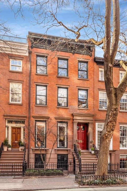 multi unit property featuring a fenced front yard and brick siding