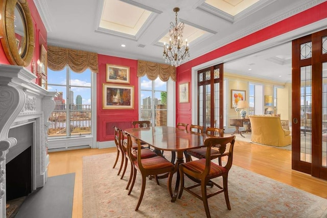 dining area featuring coffered ceiling, ornamental molding, a healthy amount of sunlight, and a fireplace