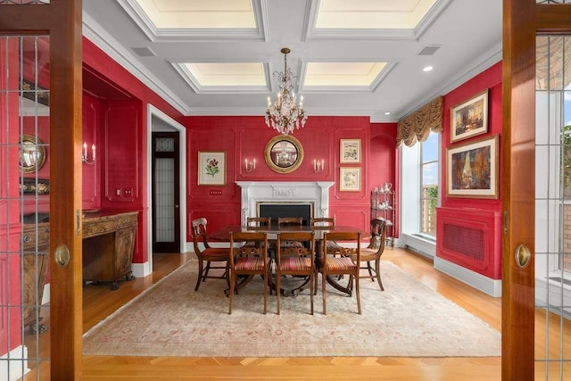 435 E 52nd St Unit 14G, New York City, NY 10022 - dining space with a fireplace, ornamental molding, a chandelier, wood finished floors, and coffered ceiling