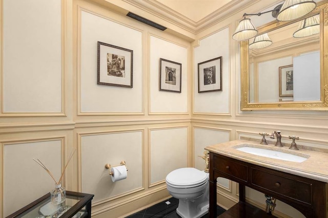 bathroom with vanity, ornamental molding, and toilet