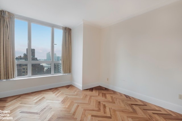 empty room featuring crown molding and light parquet flooring