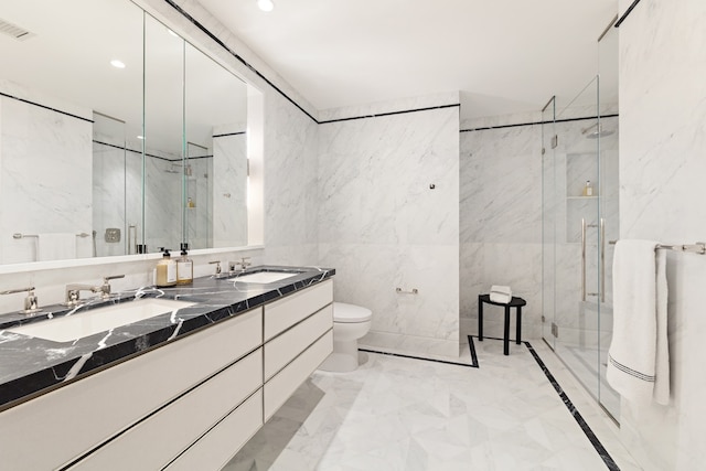 bathroom featuring vanity, toilet, an enclosed shower, and tile walls