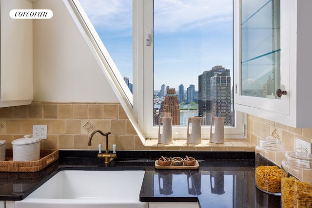 interior details with decorative backsplash, sink, and white cabinets