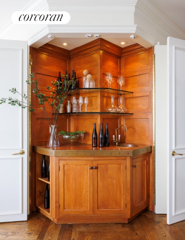 bar with sink, hardwood / wood-style floors, and crown molding