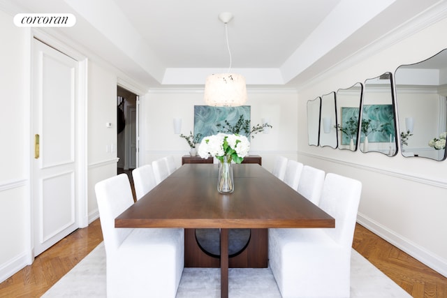 dining space featuring a tray ceiling and parquet flooring