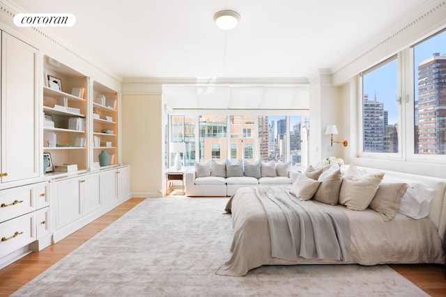 bedroom featuring multiple windows, light hardwood / wood-style flooring, and crown molding