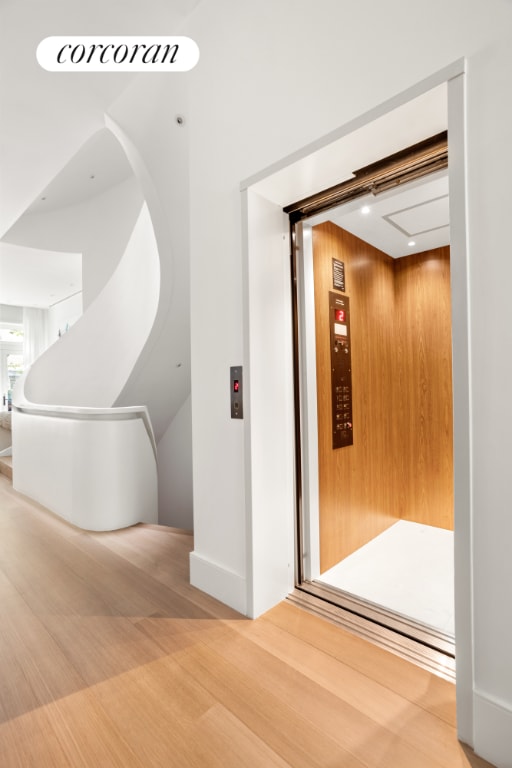 corridor featuring elevator and hardwood / wood-style floors