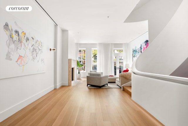 hallway featuring light wood-type flooring and french doors