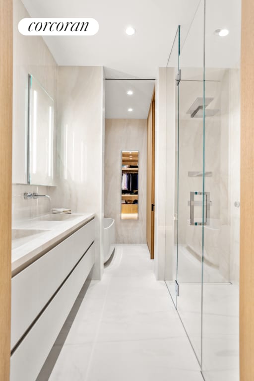 bathroom featuring tile patterned flooring, vanity, and a shower with door