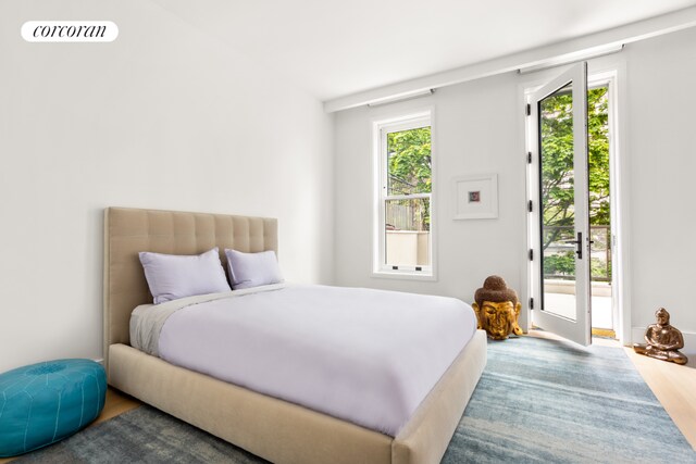 bedroom featuring access to exterior and hardwood / wood-style flooring