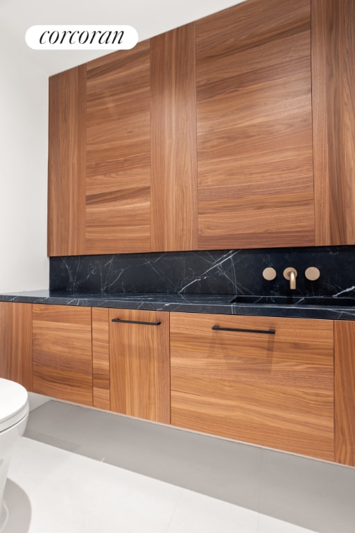 bathroom featuring toilet and backsplash