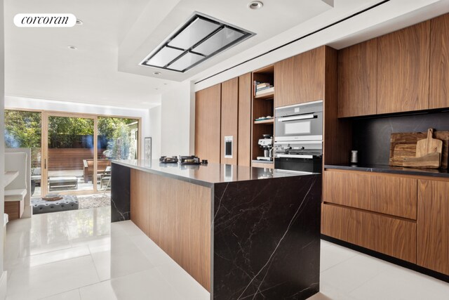 kitchen with stainless steel double oven and light tile patterned floors