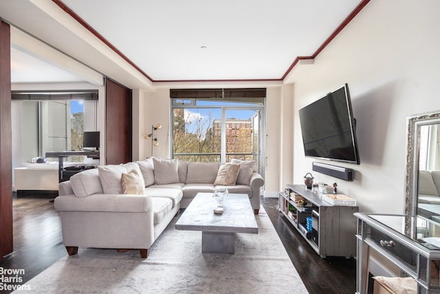 living room with crown molding, a healthy amount of sunlight, and dark wood finished floors