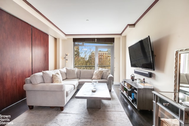 living area with ornamental molding and dark wood finished floors