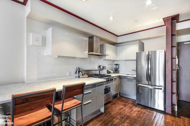 kitchen featuring tasteful backsplash, stainless steel appliances, light countertops, gray cabinetry, and wall chimney range hood