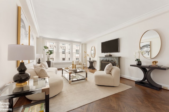 living area featuring baseboards, ornamental molding, and a fireplace