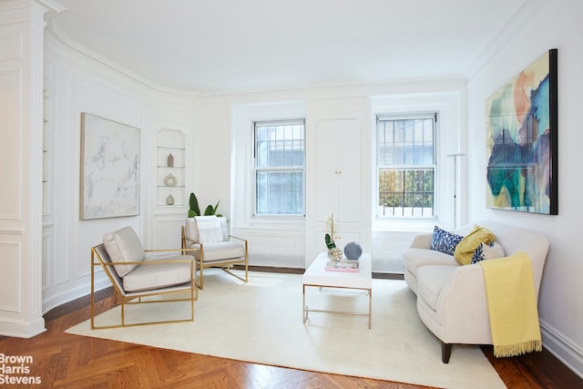 living area featuring ornamental molding, dark parquet floors, and a wealth of natural light