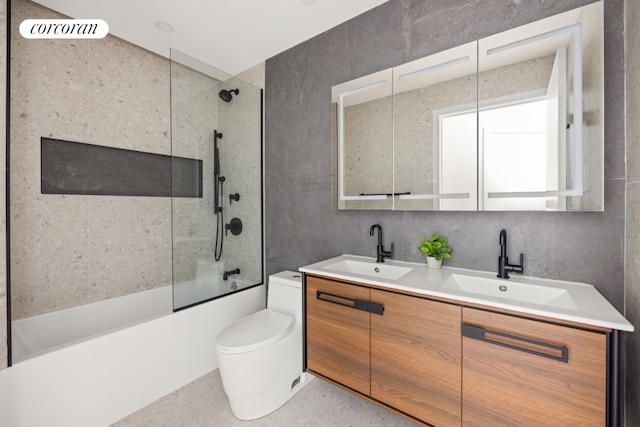 full bathroom with tiled shower / bath combo, vanity, tasteful backsplash, tile walls, and toilet