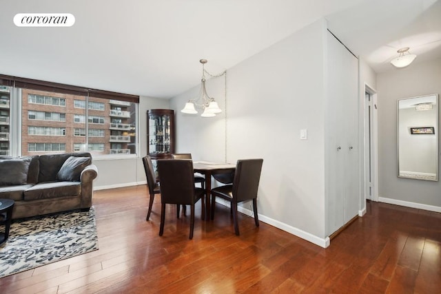 dining area with dark hardwood / wood-style flooring and an inviting chandelier