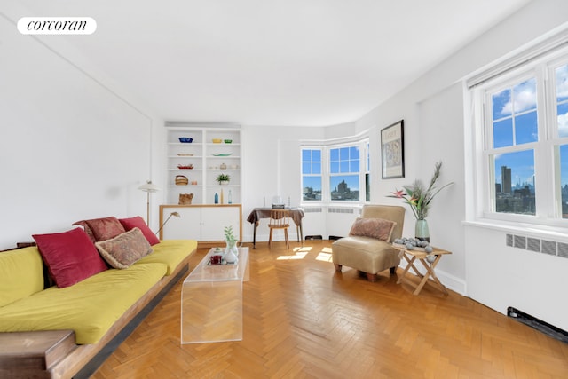 living room featuring parquet flooring and radiator heating unit