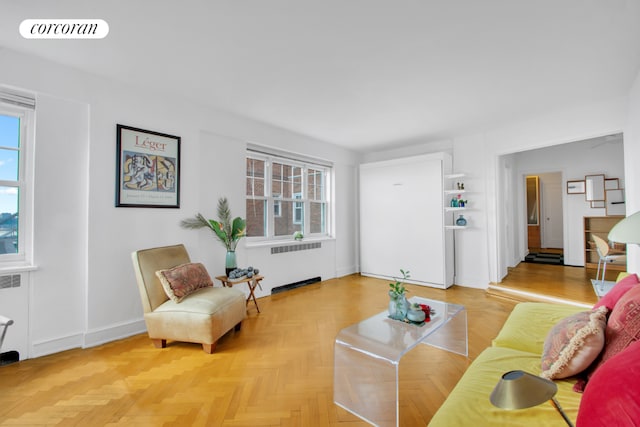 living room featuring radiator heating unit and light parquet floors