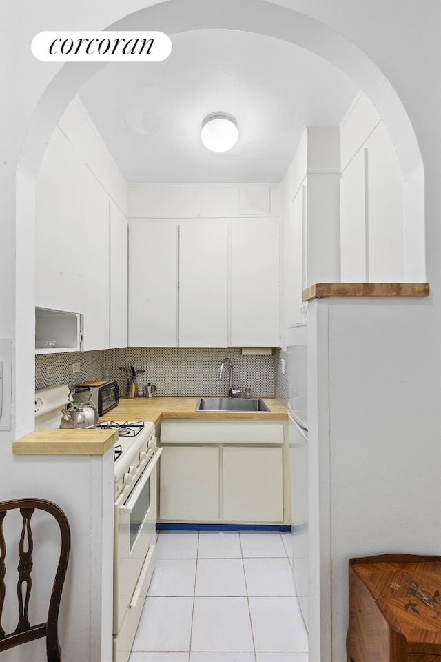 kitchen featuring light countertops, light tile patterned floors, backsplash, and a sink