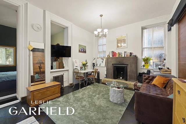 321 E 6th St, New York City, NY 10003 - living room featuring a fireplace with raised hearth, healthy amount of natural light, a chandelier, and radiator