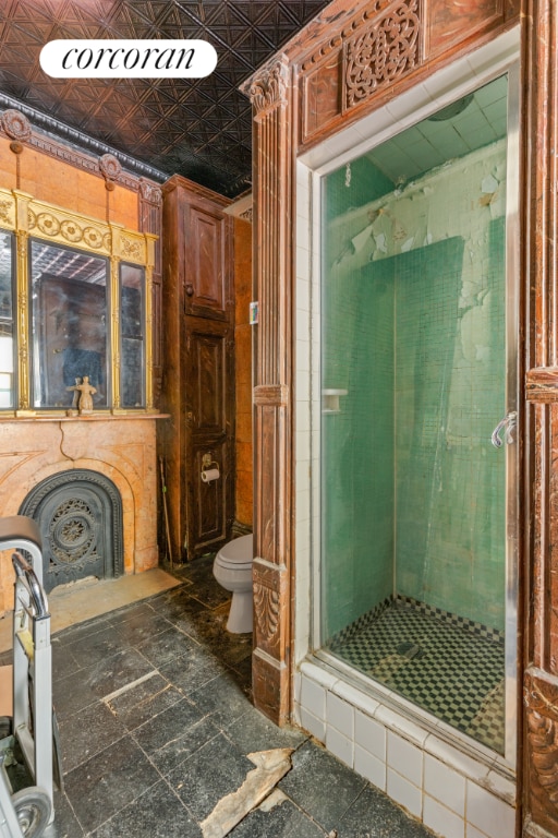 bathroom with toilet and a shower with shower door