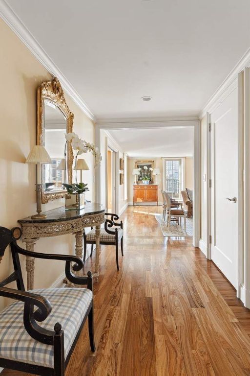 hallway with hardwood / wood-style flooring and ornamental molding