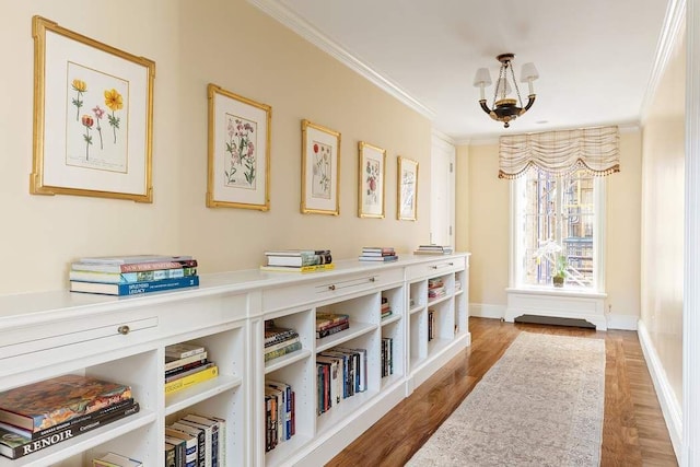 hallway featuring ornamental molding, hardwood / wood-style floors, and a notable chandelier