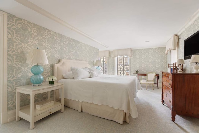 bedroom with ornamental molding and light carpet