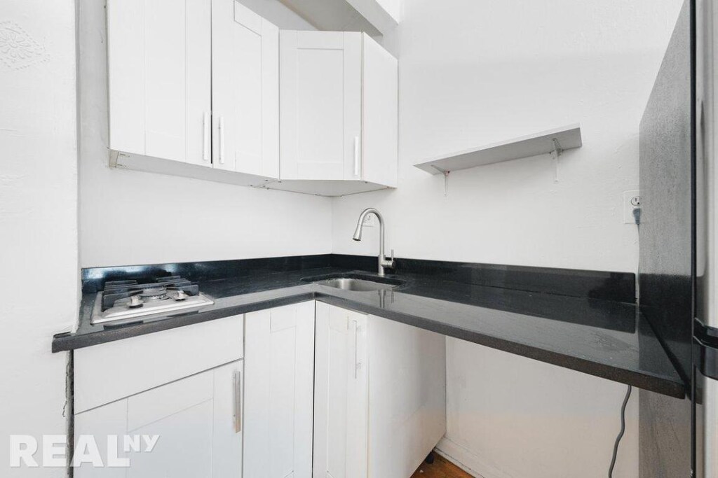 kitchen featuring sink and white cabinetry